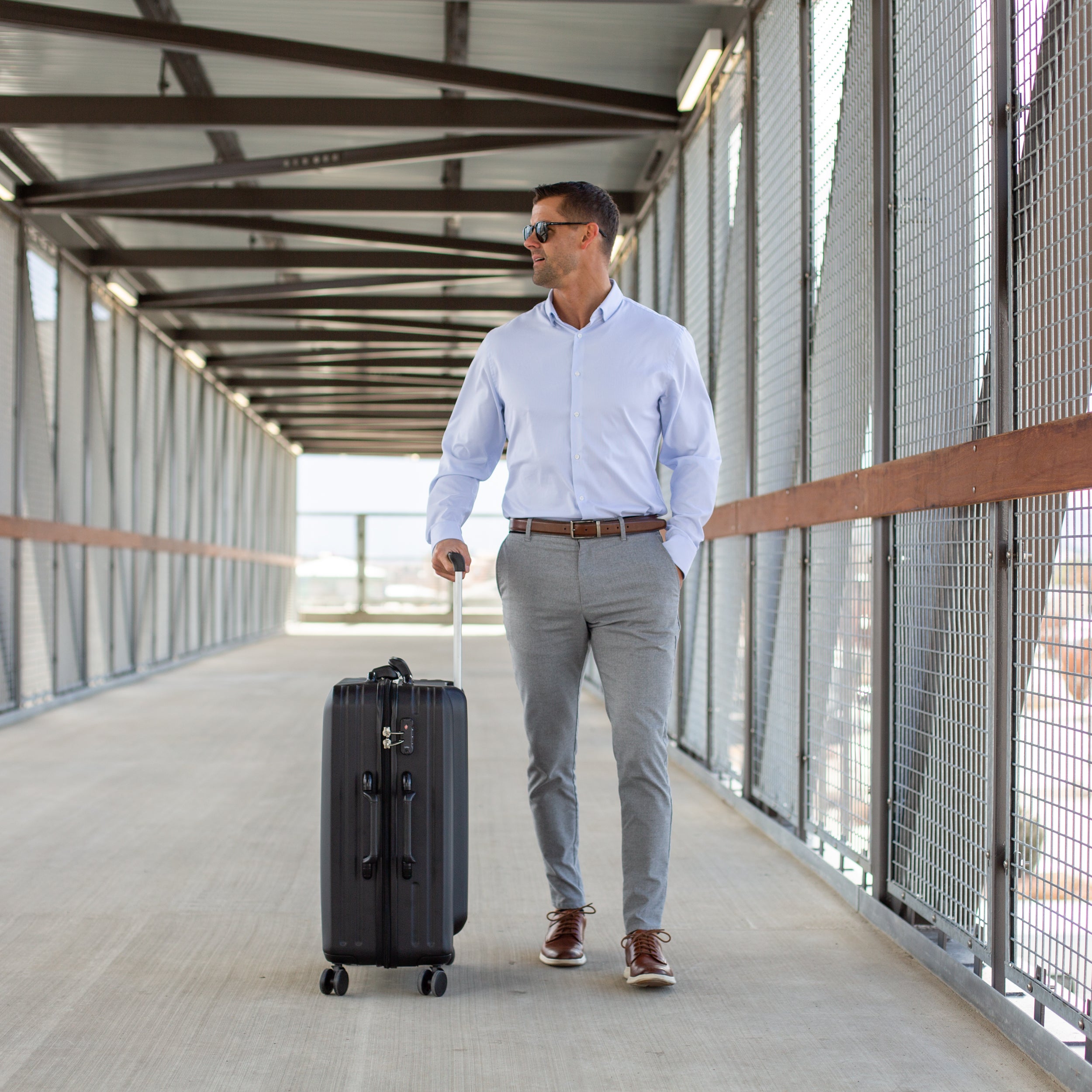 Traveler rolling the black Lazenne Elite wine suitcase through a walkway
